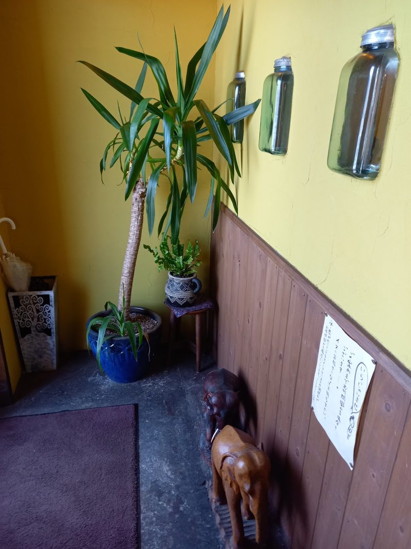 観葉植物が置かれた黄色い壁の入口ホール